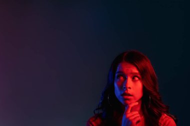 Düşünceli kadın neon ışığı insanları kırmızı reklam yapıyor.