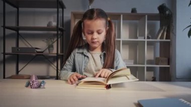 Evde kız öğrenci kitapları okuyor.