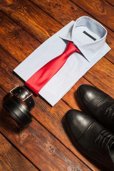 Camisa, zapatos y cinturón sobre fondo de madera — Foto de Stock