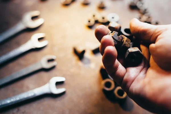 Die männliche Hand hält alte Muttern. — Stockfoto