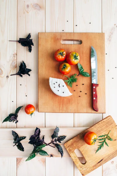 Tomates, albahaca, queso sobre fondo de madera clara — Foto de Stock