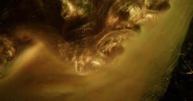 Parıltılı boya. Altın doku. Odaklanamayan sarı renkli su sıçrama partikülleri kırık cam akrilik gökkuşağı duman soyut siyah bokeh arkaplan üzerinde.