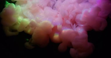 Boya dökülmüş. Gökkuşağı bulutu sıçraması. Odaklanmamış pembe mor parıltılı su parlak neon buhar soyut koyu siyah sanat arka planına yayılıyor..