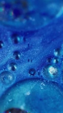 Dikey video. Parlak kabarcıklar. Odaklanamayan yaratıcı mavi. Renkli parıldayan mürekkep dokusu bulanık soyut bokeh aydınlık modern arkaplanda hareket ediyor.