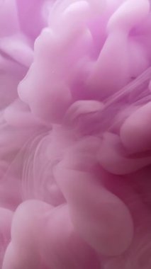 Dikey video. Duman arka planı. Sanat mürekkebi. Odaklanmamış pembe renk boya sıvı duman dokusu sıvı akışı ruhani soyut su üzerinde hareket ediyor..