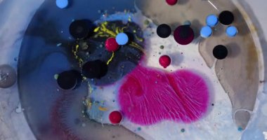 Kabarcık dokusu. Boya karışımı. Odaklanamayan mavi sarı renk, soyut sanat arka planında, akrilik yağ sıvısı koyu siyah kolajen dairesi parıldıyor..