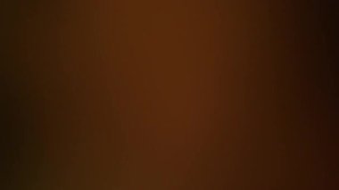 Fişekler bulanıklaşıyor. Film yanığı. Kahverengi arka planda parlayan renkli odaklanmış nokta. Gece soyut sinematik doku optik etkisini örtüyor.