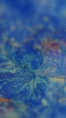 Dikey video. Parlayan ışık. Odaklanamayan yapışkan parçacıklar. Mavi sarı kumlu parçalar. Bokeh efektli bulanık modern arkaplanı aydınlatan mercek flaşları..