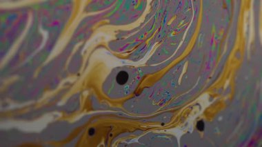 Dikey video. Yağ sıvısı. Boya lekeleri. Odaklanmamış turuncu mavi renk ıslak baloncuk deseni soyut mor arkaplan üzerinde yüzüyor.