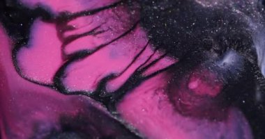 Köpüklü sıvı. Mürekkep lekeleri. Odaklanmamış mor renk akan sisli su karışımı sıvı soyut koyu siyah arkaplan üzerine dökülüyor.