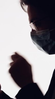 Dikey video. Salgın muhabbeti. Karantina devrede. Yüzü maskeli hasta bir adamın karanlık profilli silueti beyaz bir telefondan öksürüp mesaj atıyor..