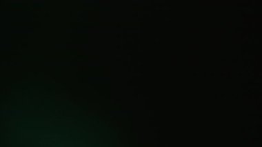 Sızıntı var. Odaklanamayan parıltı. Soyut koyu renkli siyah arkaplanda mistik bir ışık parlaması. Nostaljik film ışını yansıma sanat efekti.