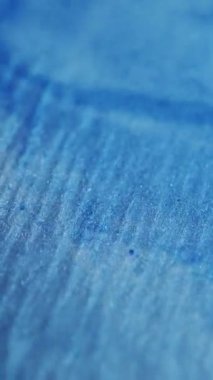 Dikey video. Mavi pırıltı pürüzsüz. Odaklanmamış damla boyası. Suda parlak dalgalı mürekkep bulanık bokeh ışığı üzerinde hareket ediyor modern arka plan.