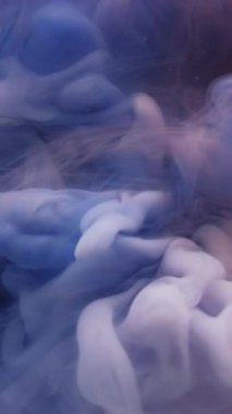 Dikey video. Sis dokusu. Mürekkep suyu. Soyut sanat üzerine yoğunlaşmamış mavi mor renkli sıvı dalga patlaması koyu siyah zemin.