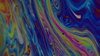 Dikey video. Boya damlası. Lekeli sanat. Soyut akrilik yeşil zemin üzerinde yüzen mavi mor renkli damlacık yağı dokusu.