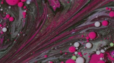 Damla karışımı. Akrilik boyalı su. Bulanık pembe mor renk yağ soyut yaratıcı arka planda parlak lekeler süzülüyor.