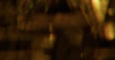 Bulanık ışıltı dokusu. Göz kamaştırıcı sanat. Soyut koyu siyah ışıklı bokeh arka planda çözünmüş sarı turuncu renkli gökkuşağı görsel mercek parlaklığı.