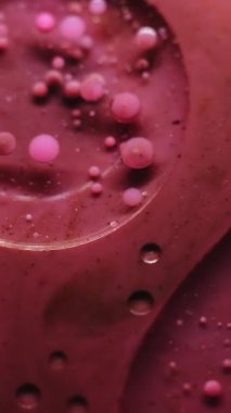 Dikey video. Yağ damlası. Jel köpükleri. Soyut sanat arkaplanına dökülen su sıvısındaki pembemsi pembe boya yuvarlak deseni..