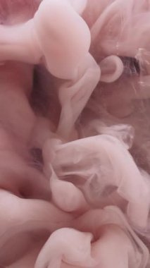 Dikey video. Mürekkep su sıçratır. Akışkan bulut. Soyut koyu siyah sanat arka planında yüzen odaksız pembe renkli ruhani kimyasal akış sıvısı.