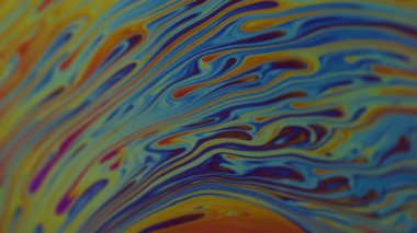 Dikey video. Yakıt dökülüyor. Yanardöner sanat. Soyut arkaplanda yüzen bulanık mavi mor renkli kimyasal boya..