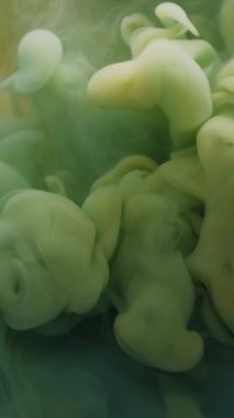 Dikey video. Duman dalgası. Soyut akış. Arka planda, su boyası bulutu ruhani dokusunda çözünmüş mavi sarı renkli sıvı mürekkep..