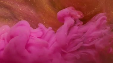 Mürekkep fırıldağı. Arkaplanı boya. Odaklanmamış pembe turuncu altın rengi duman parlatıcısı yaratıcı sanat soyutlamasına sıçrıyor..