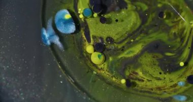 Boya baloncukları. Yağlı boya topu. Soyut sanat arka planında yüzen parlak suyun etrafında sönük sarı mavi parıltı dokusu.