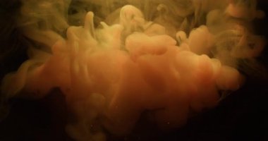 Su altı buharı. Boya suyu akışı. Bulanık pembe turuncu renk sıvı parlayan bulut deseni sis gökkuşağı parçacıkları soyut koyu siyah arkaplan üzerine dökülür.