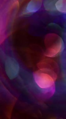 Dikey video. Kaleydoskop ışınları. Odaklanmış ışık fişekleri. Işıldayan yeşil renk parçacıkları mercek flaşı Bokeh etkisi ile bulanık arkaplan üzerinde hareket ediyor.