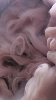 Dikey video. Duman arka planı. Sanat mürekkebi. Odaklanmamış mor renk boya sıvı duman dokusu sıvı akışı göksel soyut su üzerinde hareket ediyor..