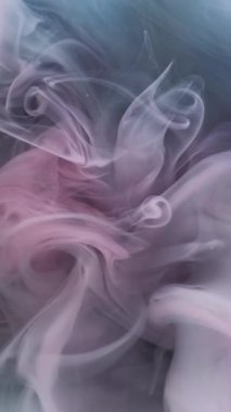 Dikey video. Renkli duman dokusu. Suyu boya. Odaklanamayan mavi pembe patlama bulutu karışımı ruhani sıvı soyut sanat arka planına yayılıyor..