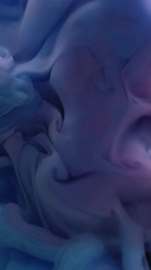 Dikey video. Duman dalgası. Soyut akış. Su boyasında çözünmüş mavi pembe renkli sıvı mürekkep sanat arka planında bulutsal ruhani doku sıçratıyor..