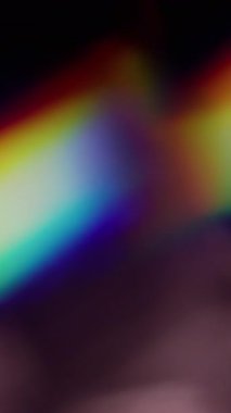 Dikey video. Bulanık ışık. Soyut aydınlanma. Odaklanmamış mavi yeşil çok renkli gökkuşağı optik spektrum sanat arka planında parıldıyor.