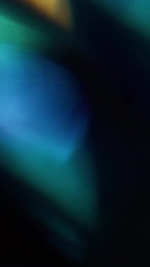 Dikey video. Bokeh ışığı. Bulanık çember parlıyor. Odaksız mavi, altın sarısı, yanıp sönen mercek soyut sanat, koyu siyah arkaplan..