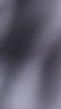 Dikey video. Parıltı ışını. Bulanık görsel doku. Odaklanmamış beyaz mercek parlamaları, koyu siyah soyut sanat arka planına yayılan yanıp sönen kıvılcım etkisi yapar..