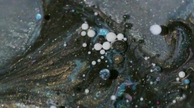 Parlak köpük dokusu. Yağlı boya pigmenti. Odaklanmamış mavi beyaz altın rengi ışıltılı sıvı baloncuklar soyut arkaplanda yüzer.