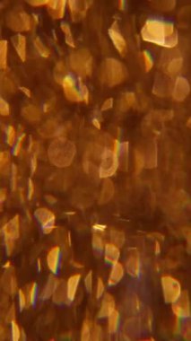 Dikey video. Kıvılcım dokusu. Bulanık mercek parlaması. Sanatın koyu siyah arka planında odaksız sarı mavi renk bokeh açık kaleydoskop gökkuşağı spektrumuName.