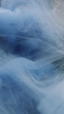 Dikey video. Bulut dalgası. Boya karışımı. Odaklanmamış mavi renk su mürekkep dokusu kimyasal buhar sıvısı soyut koyu siyah sanat arka planında yüzüyor.