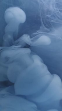 Dikey video. Ruhsal buhar. Arkaplanı boya. Odaklanamayan mavi sis dokusu kimyasal sıvı duman patlaması soyut sanatta dönen suyu karıştırıyor.