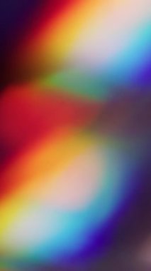 Dikey video. Işın kıvılcımı. Bulanık parıltı. Soyut sanatın koyu siyah arka planında sönük mavi, çok renkli gökkuşağı spektrum parıltısı ışığı.