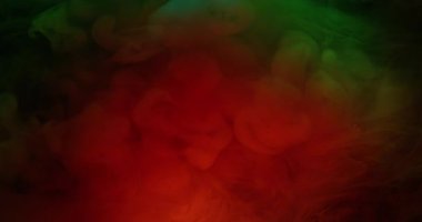 Boya karışımı. Neon sis akışı. Odaklanmamış turuncu renkli sim duman bulutu gökkuşağı sanat suyu soyut koyu siyah arka planda yayılıyor..