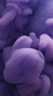 Dikey video. Mürekkep damlası su. Renk sıçraması. Odaklanmamış mavi mor boya dokusu soyut sanat arka planında dönen kimyasal bulut sıvısı akışı.