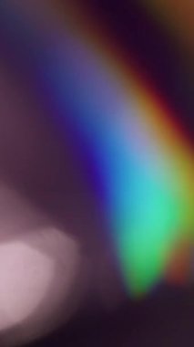 Dikey video. Gökkuşağı dairesi. Bulanık ışık huzmesi. Soyut Bokeh koyu siyah arkaplan üzerinde odaklanmış kırmızı yeşil renkli işaret fişeği kıvılcımı ışık deseni tayfı.