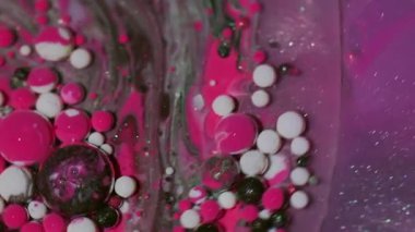 Mürekkep damlası. Akış karışımı. Odaklanmamış pembe beyaz yağ pigmenti su kabarcıkları soyut arkaplanda dönen ıslak damlalar.