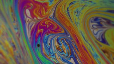 Dikey video. Boya karışımı. Su yakıtı. Odaklanamayan sarı mor renkli mürekkep soyut akrilik arka planda mavi lekeler sızdırıyor..