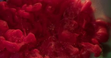 Kırmızı mürekkep dökülmüş. Işıltılı su sıçratma. Odaklanmamış sıcak renkli gökkuşağı parlak bulut dumanı deseni sim sisi soyut akrilik bokeh arkaplan üzerine yayılıyor.