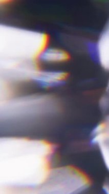 Dikey video. Çember ışığı. Bulanık parıltı. Odaklanmamış mavi turuncu rengin yanıp sönmesi soyut arkaplanda yüzen optik yansıma.