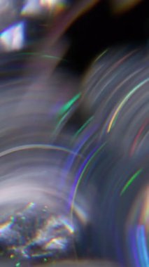 Dikey video. Disko daireleri. Bulanık işaret ışığı. Odaklanmamış yeşil turuncu lens soyut koyu siyah arkaplan üzerindeki yansıma spektrum ışığı.