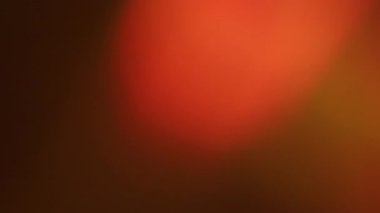 Odaklanmamış sızıntı. Lens yansıması. Kırmızı turuncu film koyu arkaplanda parlaklığı yakar. Soyut gecede ışık rengi kaybolur.