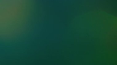 Bulanık gradyan spektrumu. Retro lens prizması. Koyu arkaplanda parlayan yeşil mavi sönmüş ışık. Eski film ışıldayan ışık geçişi.